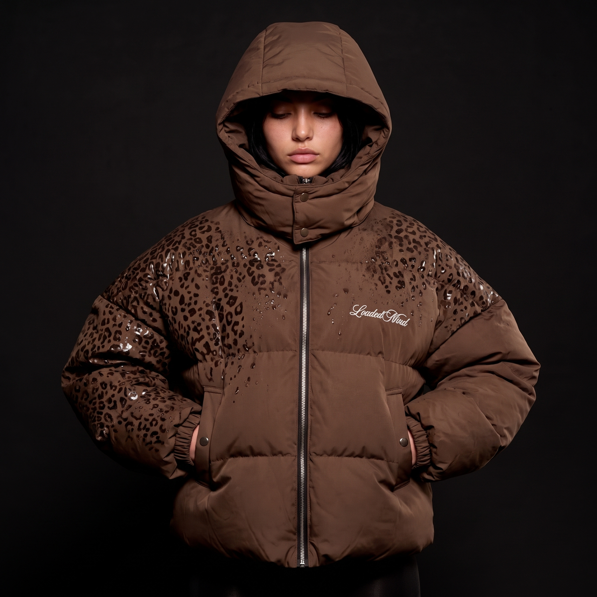 Brown leopard reveal puffer with the hood up, pattern showing where wet